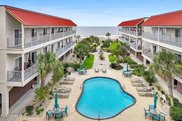 community pool featuring a water view and a patio