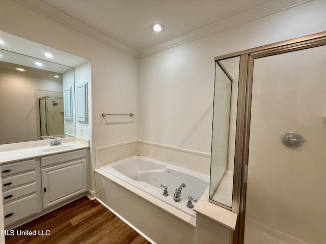 bathroom featuring a jetted tub, crown molding, a stall shower, wood finished floors, and vanity