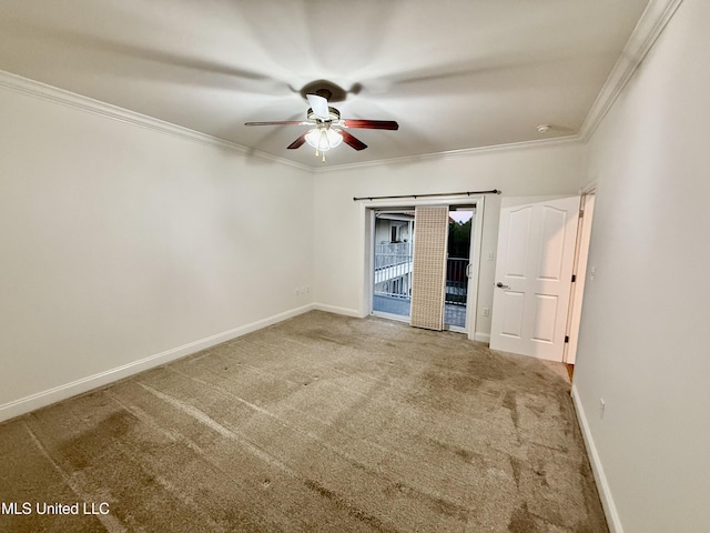 carpeted empty room with baseboards, a ceiling fan, and crown molding