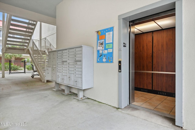 view of home's community featuring mail area, stairway, and fence