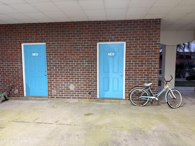 view of exterior entry featuring brick siding