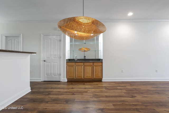 bar featuring dark wood-type flooring, pendant lighting, recessed lighting, crown molding, and baseboards