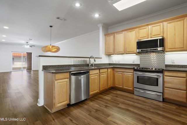 kitchen featuring visible vents, a sink, dark wood-style floors, a peninsula, and appliances with stainless steel finishes