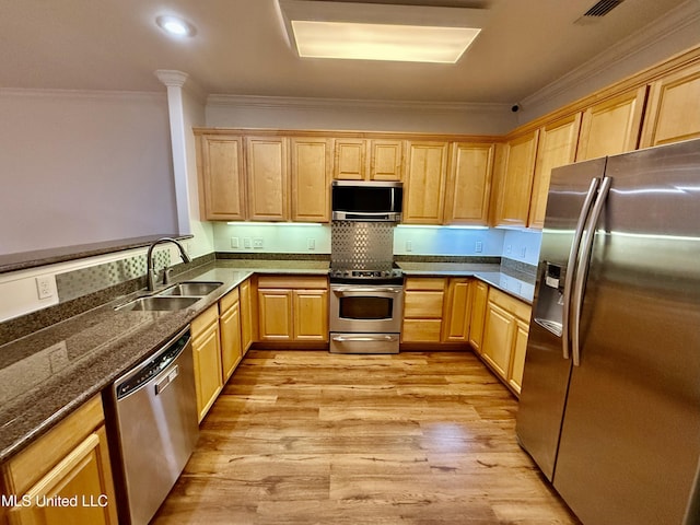 kitchen with light brown cabinets, appliances with stainless steel finishes, and a sink