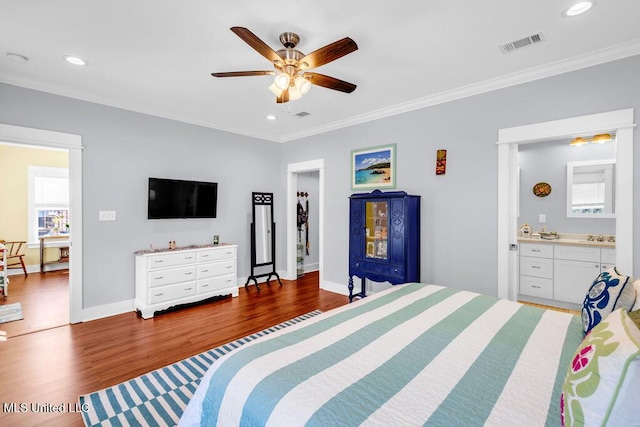 bedroom with baseboards, visible vents, ornamental molding, wood finished floors, and recessed lighting