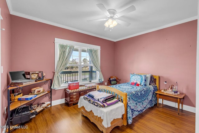 bedroom with baseboards, wood finished floors, and crown molding