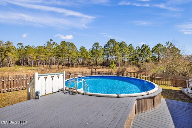 view of swimming pool featuring a fenced in pool, a fenced backyard, and a deck