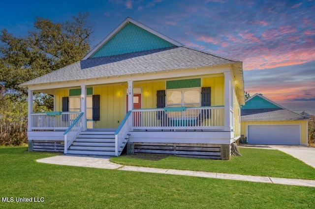 view of front facade with a garage, a front yard, covered porch, and roof with shingles