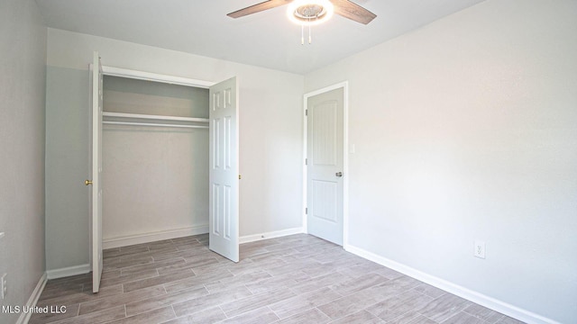 unfurnished bedroom with a closet, light wood-type flooring, a ceiling fan, and baseboards