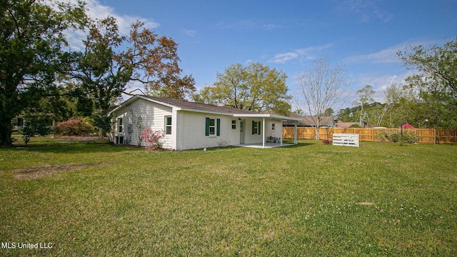 rear view of property with brick siding, a yard, fence, and a patio