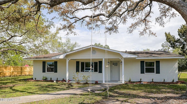 single story home with brick siding, a front yard, and fence