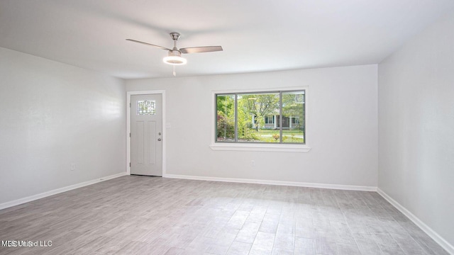 interior space with a ceiling fan, baseboards, and wood finished floors