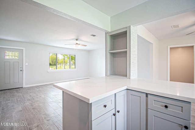 kitchen with open floor plan, gray cabinets, visible vents, and a ceiling fan