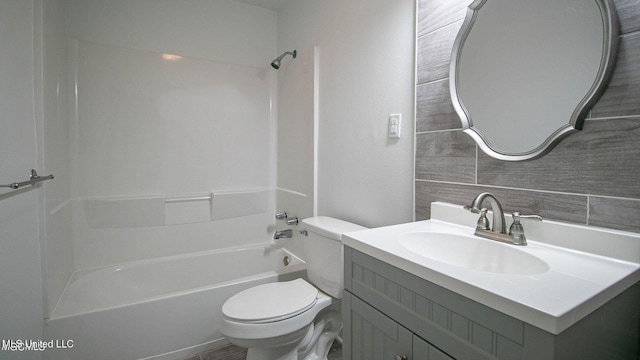 bathroom with tub / shower combination, vanity, and toilet