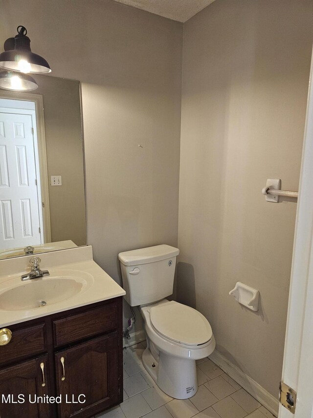 5746 Eagleston Dr, Olive Branch, MS 38654 - half bathroom featuring tile patterned flooring, vanity, baseboards, and toilet