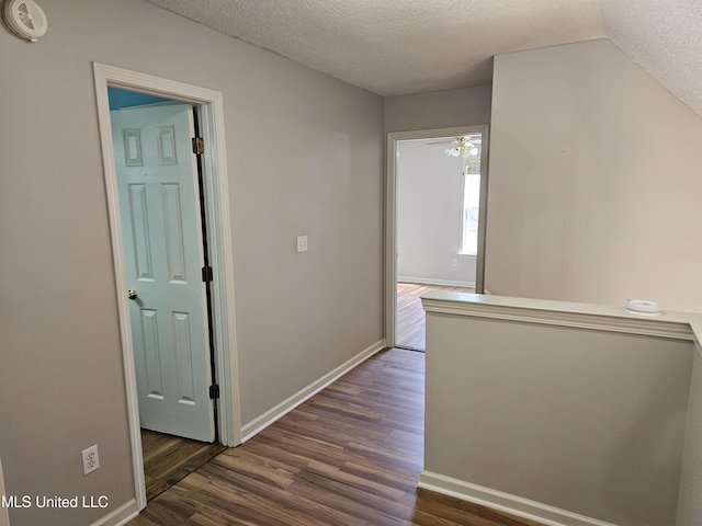 5746 Eagleston Dr, Olive Branch, MS 38654 - corridor with vaulted ceiling, a textured ceiling, baseboards, and dark wood finished floors