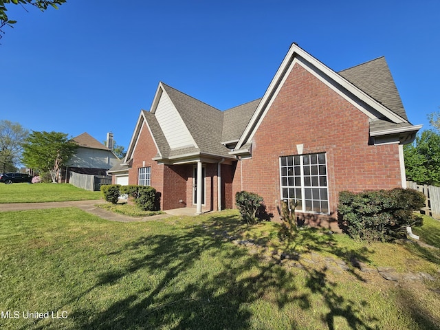 5746 Eagleston Dr, Olive Branch, MS 38654 - view of front of house with a shingled roof, fence, a front lawn, and brick siding