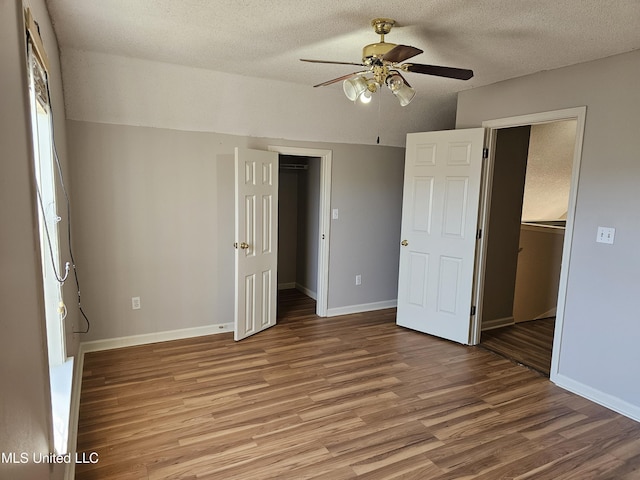 5746 Eagleston Dr, Olive Branch, MS 38654 - unfurnished bedroom featuring a closet, baseboards, a spacious closet, a ceiling fan, and wood finished floors