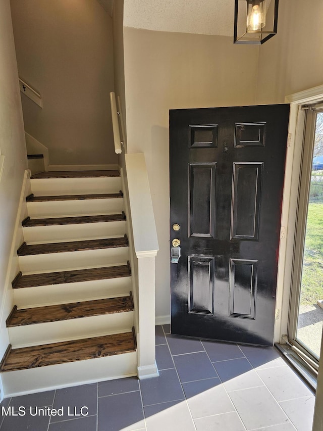 5746 Eagleston Dr, Olive Branch, MS 38654 - foyer featuring dark tile patterned floors, plenty of natural light, and stairway