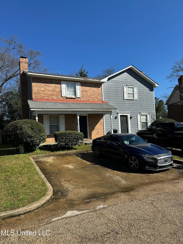 traditional-style home with brick siding and a chimney