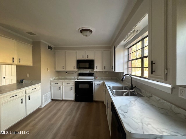 kitchen with visible vents, dark wood finished floors, a sink, black appliances, and white cabinets