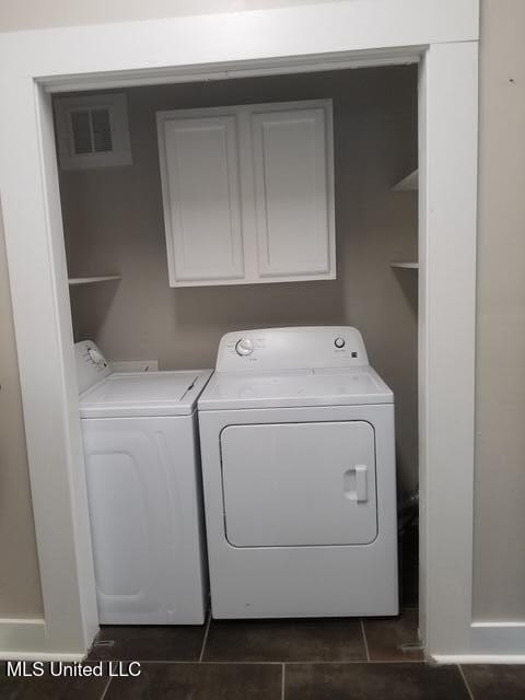 3 New St, Natchez, MS 39120 - washroom featuring washing machine and clothes dryer, cabinet space, and dark tile patterned flooring