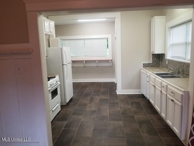 3 New St, Natchez, MS 39120 - kitchen with a sink, white range with gas cooktop, white cabinets, light countertops, and decorative backsplash