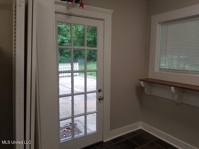 3 New St, Natchez, MS 39120 - doorway to outside with baseboards and dark tile patterned floors