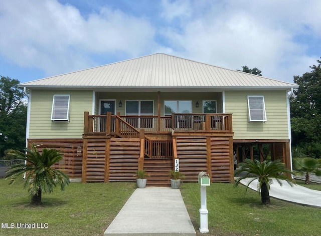 view of front of home featuring covered porch, a front yard, stairs, and metal roof