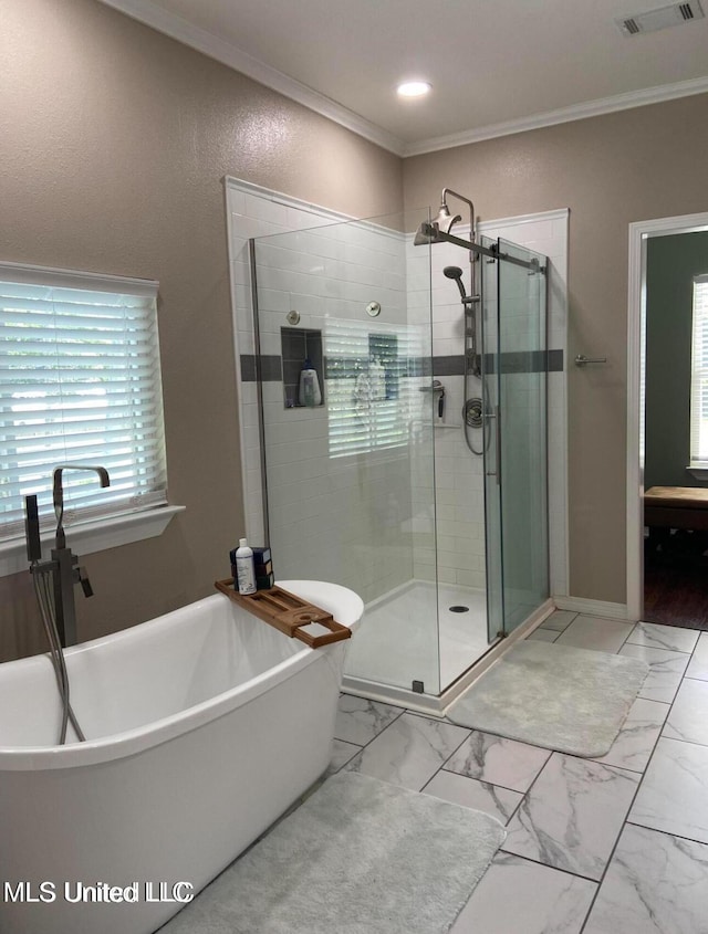 full bathroom featuring a stall shower, a freestanding tub, crown molding, marble finish floor, and visible vents