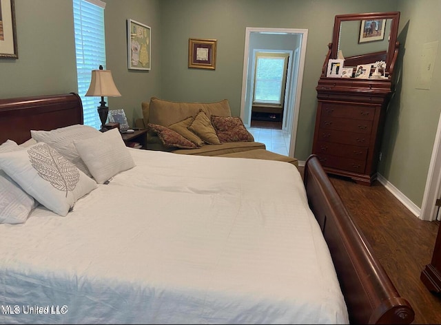bedroom featuring baseboards and dark wood-style floors