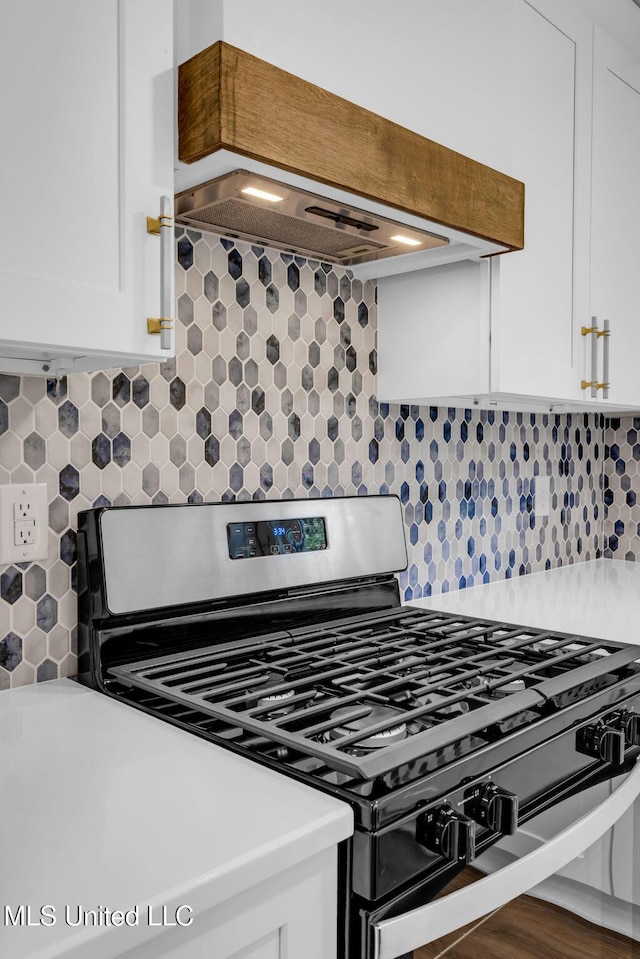 6544 Columbus Cir, Ocean Springs, MS 39564 - kitchen featuring stainless steel gas stove, extractor fan, white cabinetry, and tasteful backsplash
