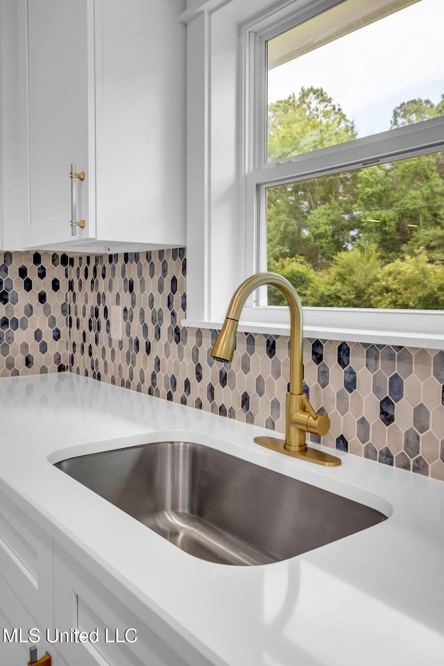 6544 Columbus Cir, Ocean Springs, MS 39564 - kitchen view of light countertops, white cabinetry, and tasteful backsplash