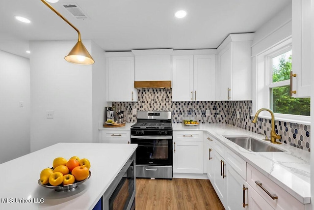 6544 Columbus Cir, Ocean Springs, MS 39564 - kitchen with appliances with stainless steel finishes, white cabinetry, decorative backsplash, light wood-style floors, and recessed lighting
