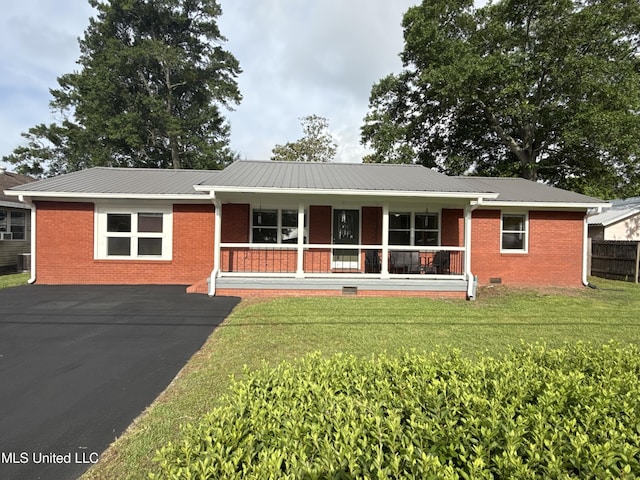 single story home featuring covered porch, metal roof, brick siding, and a front yard
