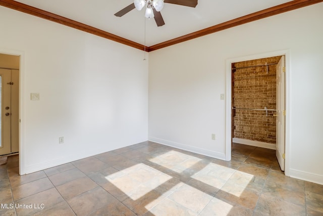 empty room with a ceiling fan, stone finish floor, brick wall, baseboards, and ornamental molding