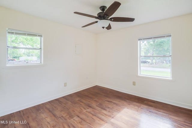 spare room with a ceiling fan, a wealth of natural light, and wood finished floors