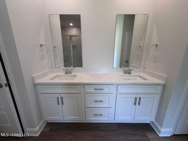 bathroom with a sink, a shower stall, and wood finished floors