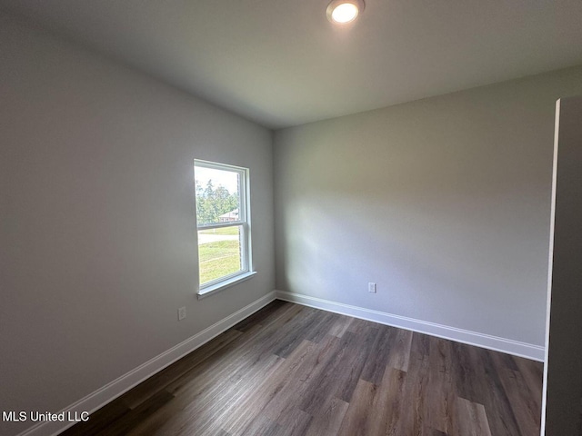 unfurnished room with dark wood-style floors and baseboards