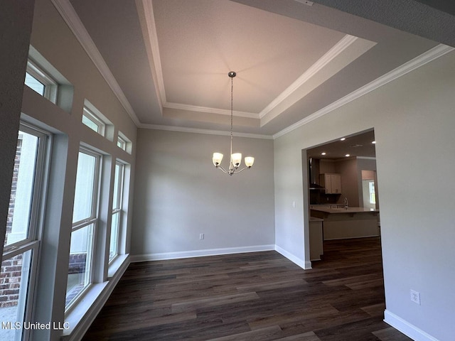 unfurnished dining area featuring baseboards, dark wood finished floors, an inviting chandelier, a tray ceiling, and crown molding