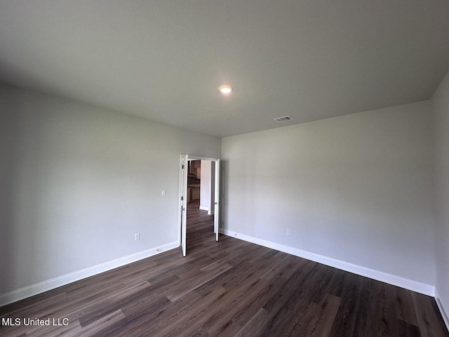 unfurnished room featuring dark wood-style floors, recessed lighting, visible vents, and baseboards