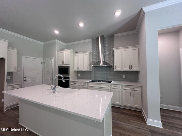 kitchen featuring white cabinets, a sink, and wall chimney range hood