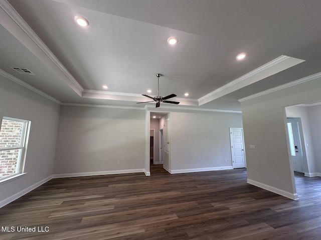 spare room with a raised ceiling, visible vents, dark wood finished floors, and baseboards