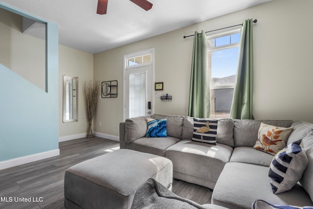 living room featuring dark wood-type flooring and ceiling fan