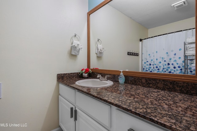 bathroom featuring vanity, a shower with shower curtain, and a textured ceiling