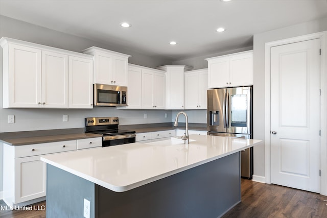 kitchen with appliances with stainless steel finishes, a sink, and white cabinetry