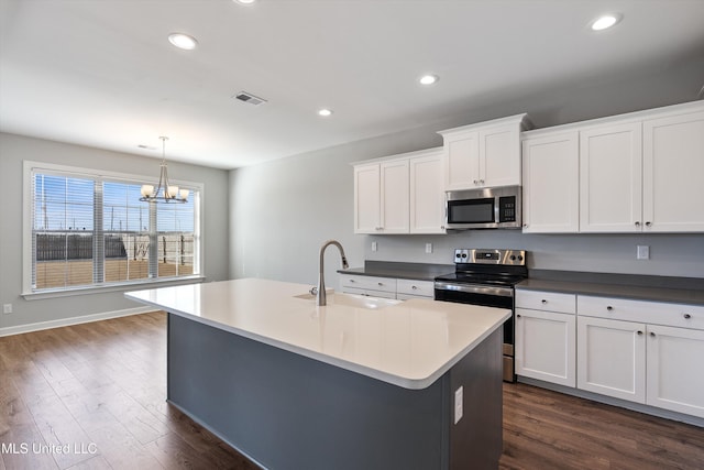 kitchen featuring recessed lighting, stainless steel appliances, a sink, dark wood-style floors, and an island with sink