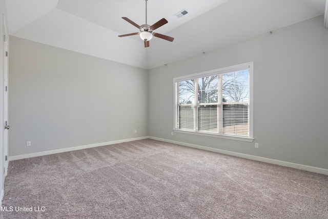 carpeted empty room with vaulted ceiling, visible vents, ceiling fan, and baseboards