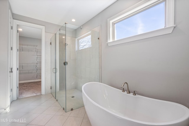 full bath featuring recessed lighting, a soaking tub, a spacious closet, a stall shower, and tile patterned floors