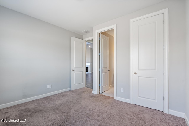 unfurnished bedroom featuring carpet floors, visible vents, and baseboards